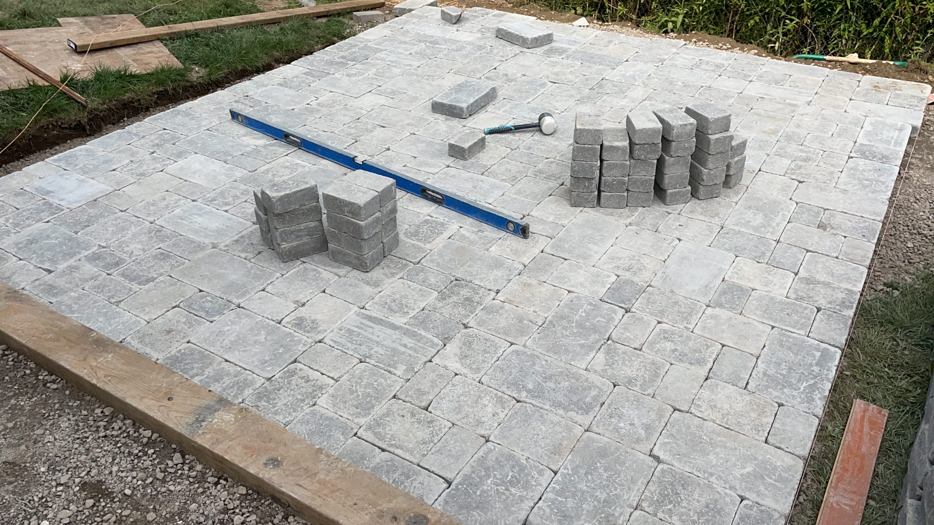 Newly laid tumbled grey interlocking paver patio with screed rails in Toronto