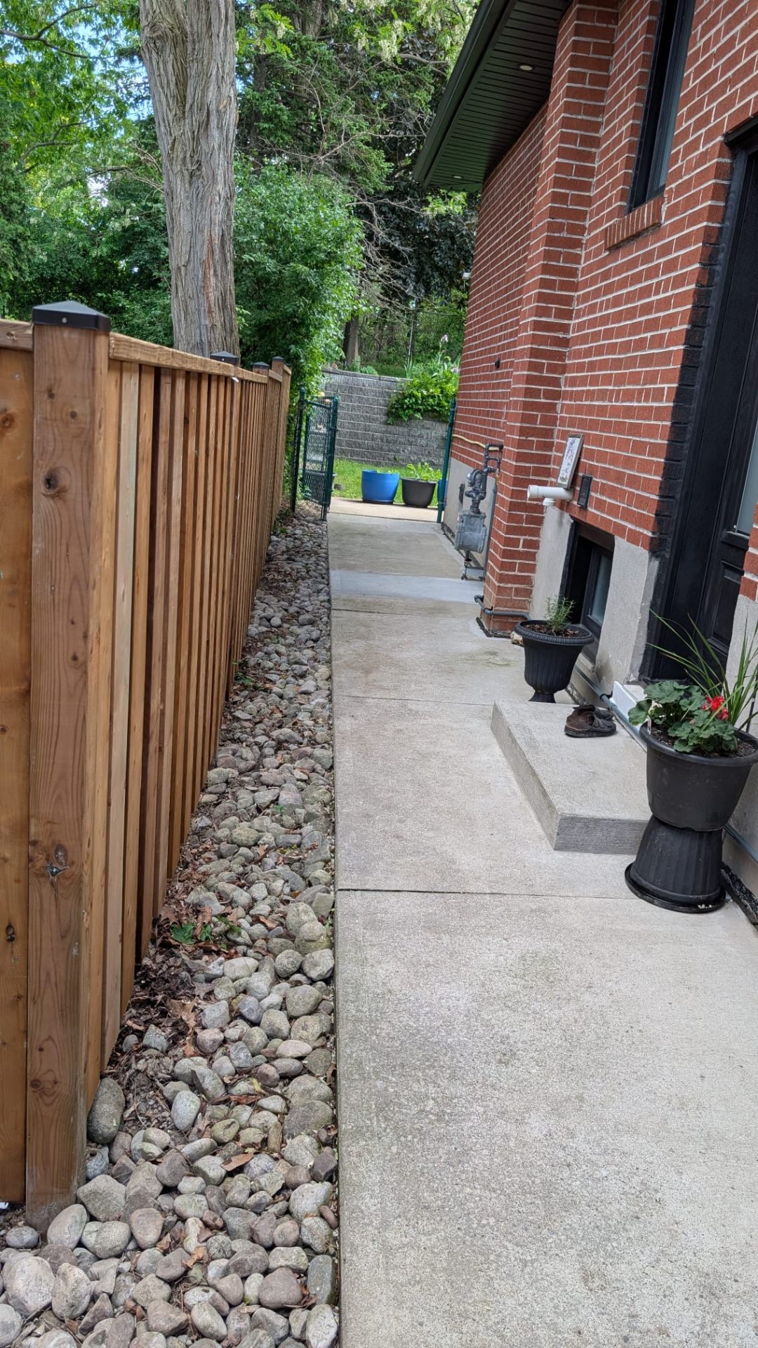Concrete side walkway with river rock bed and cedar fence in Toronto